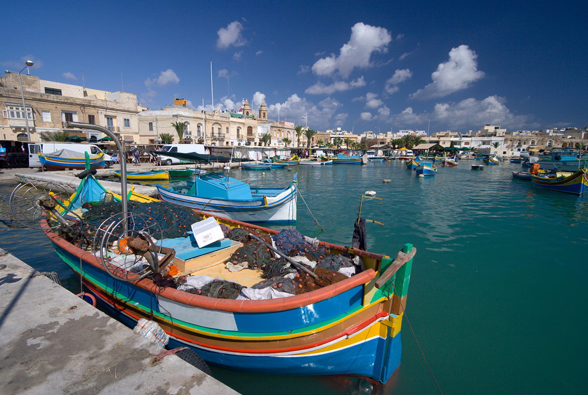Das Fischerdorf Marsaxlokk glänzt mit einem stimmungsvollen Hafen, in dem bunte Boote ankern.