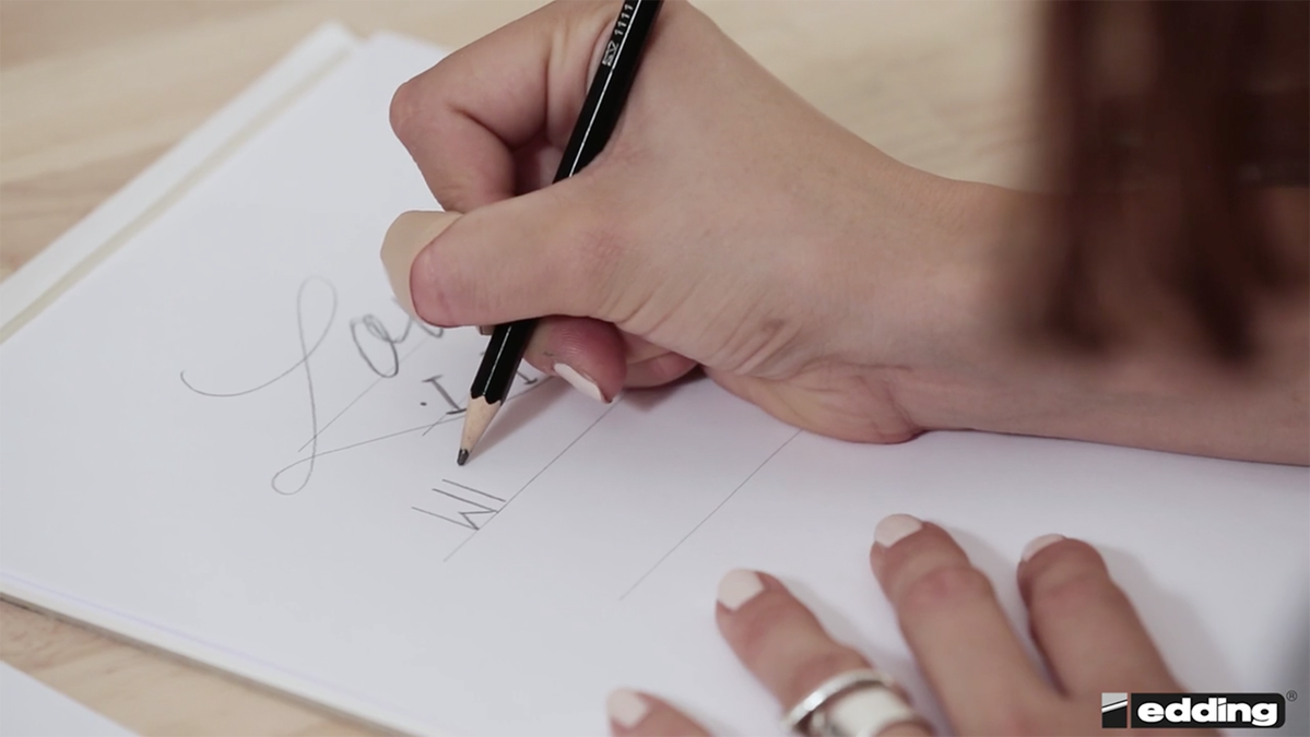 Dafür zeichnet die Handlettering-Expertin zunächst ihren Entwurf vor und überträgt ihn dann auf ihren gewünschten Untergrund.