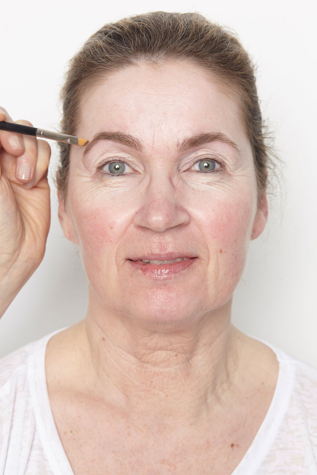 Feinarbeit: Gaby Augenbrauen werden zurechtgezupft, das vergrößert die Augen. Lücken mit einem Augenbrauenstift füllen, mit einem Pinsel weichzeichnen.