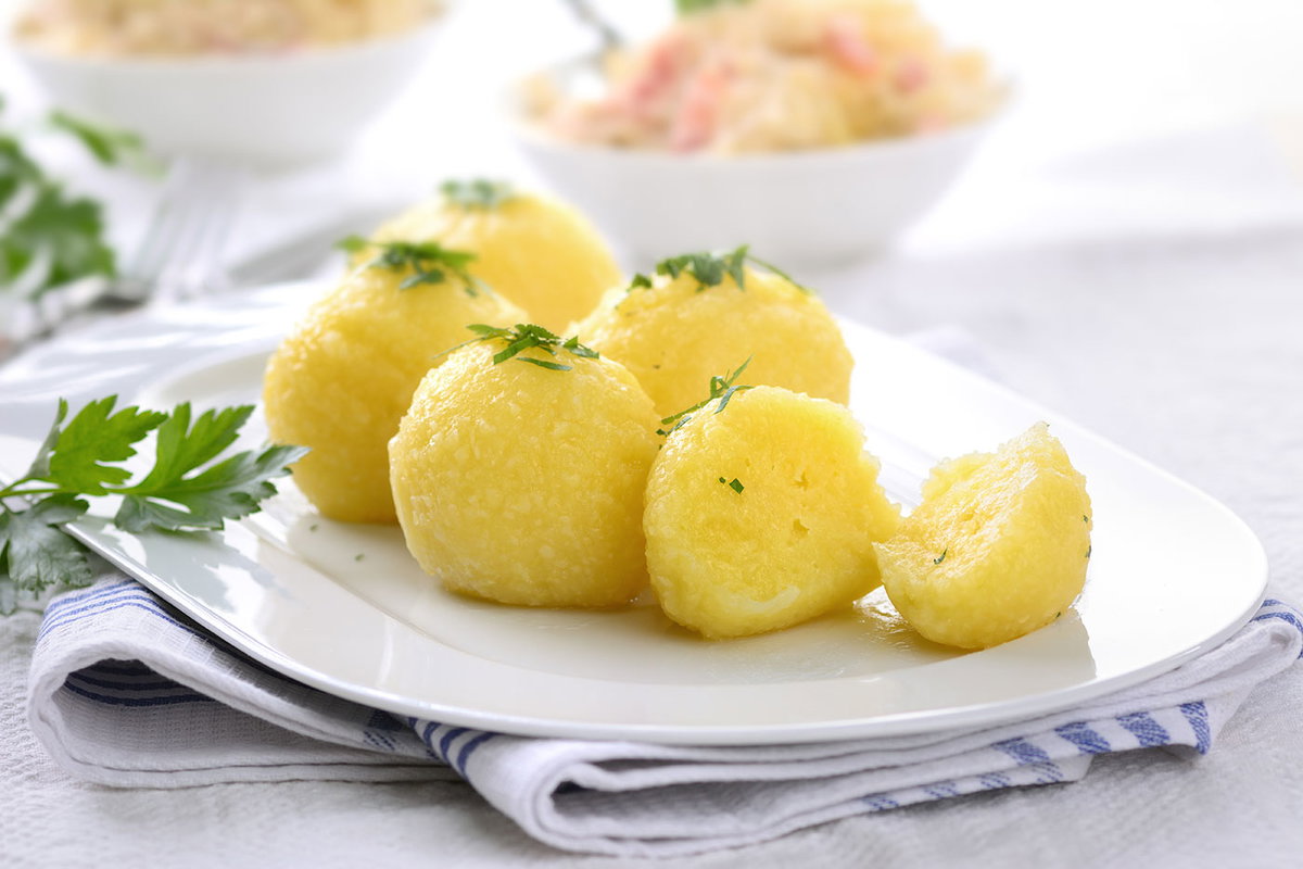 Kartoffelklöße mit Petersilie garniert auf einer Servierplatte