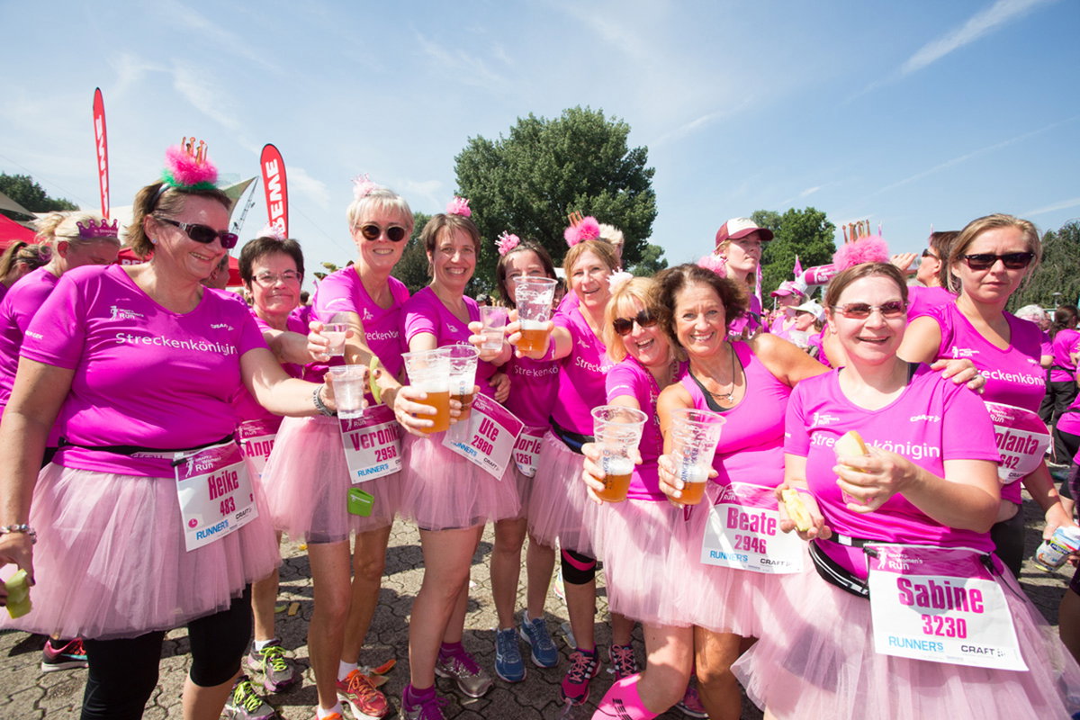 Viele Frauen in Kostümen laufen beim Women's Run mit