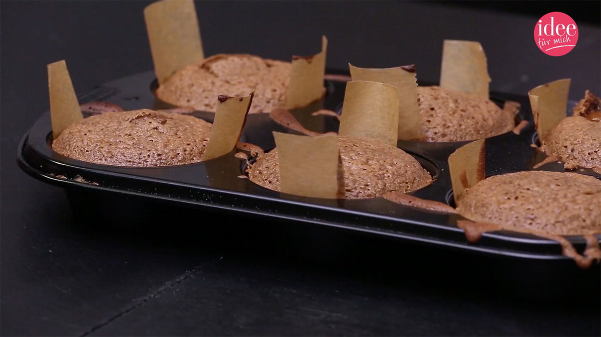 Mit Backpapierstreifen ausgelegtes Muffinblech mit Muffins
