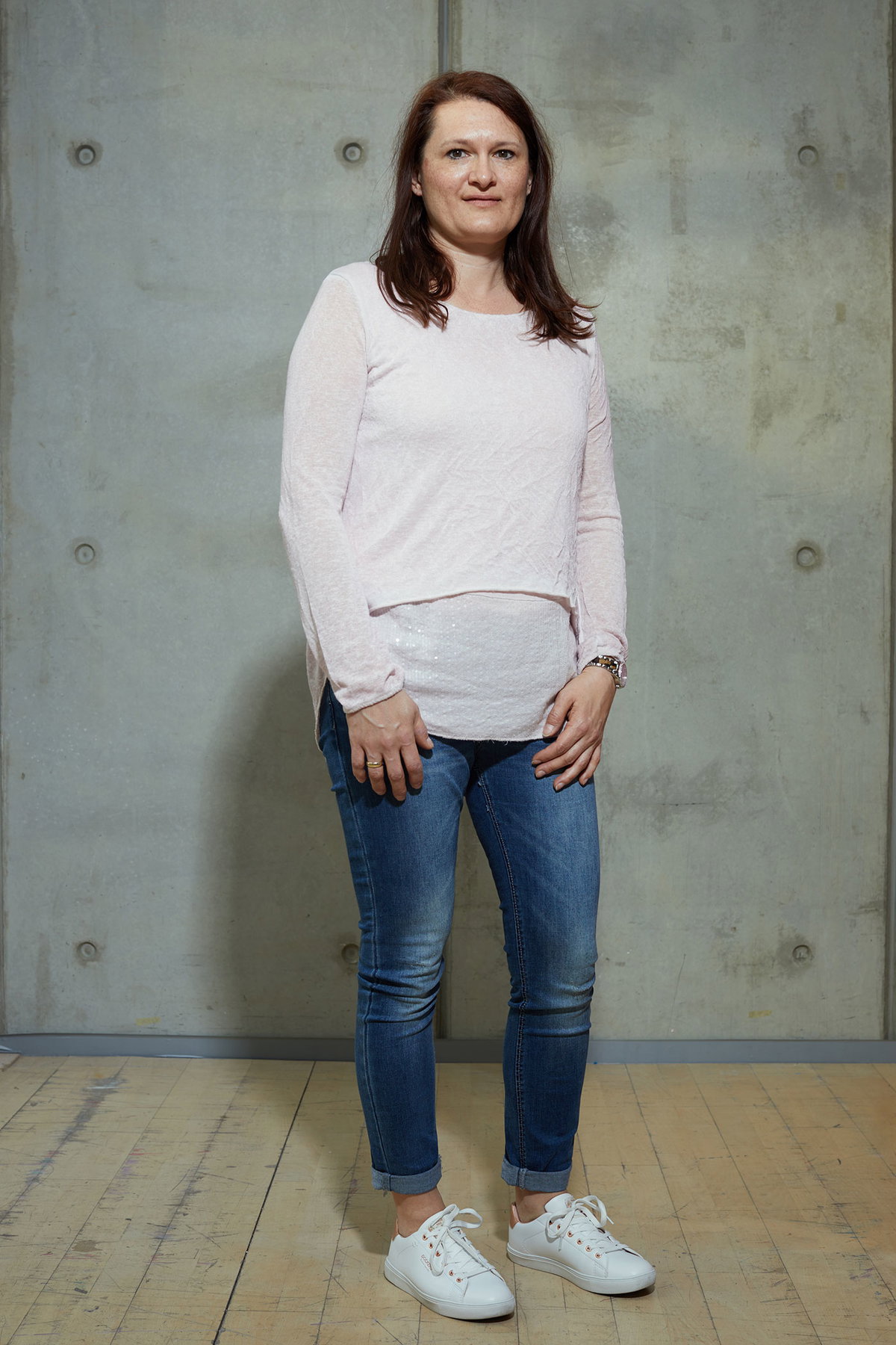 Inga im Vorher-Look mit hellem Oberteil zur Jeans und weißen Turnschuhen