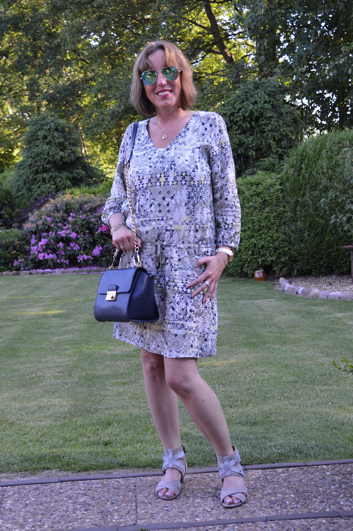 Attraktive Frau mittleren Alters in gemustertem Sommerkleid