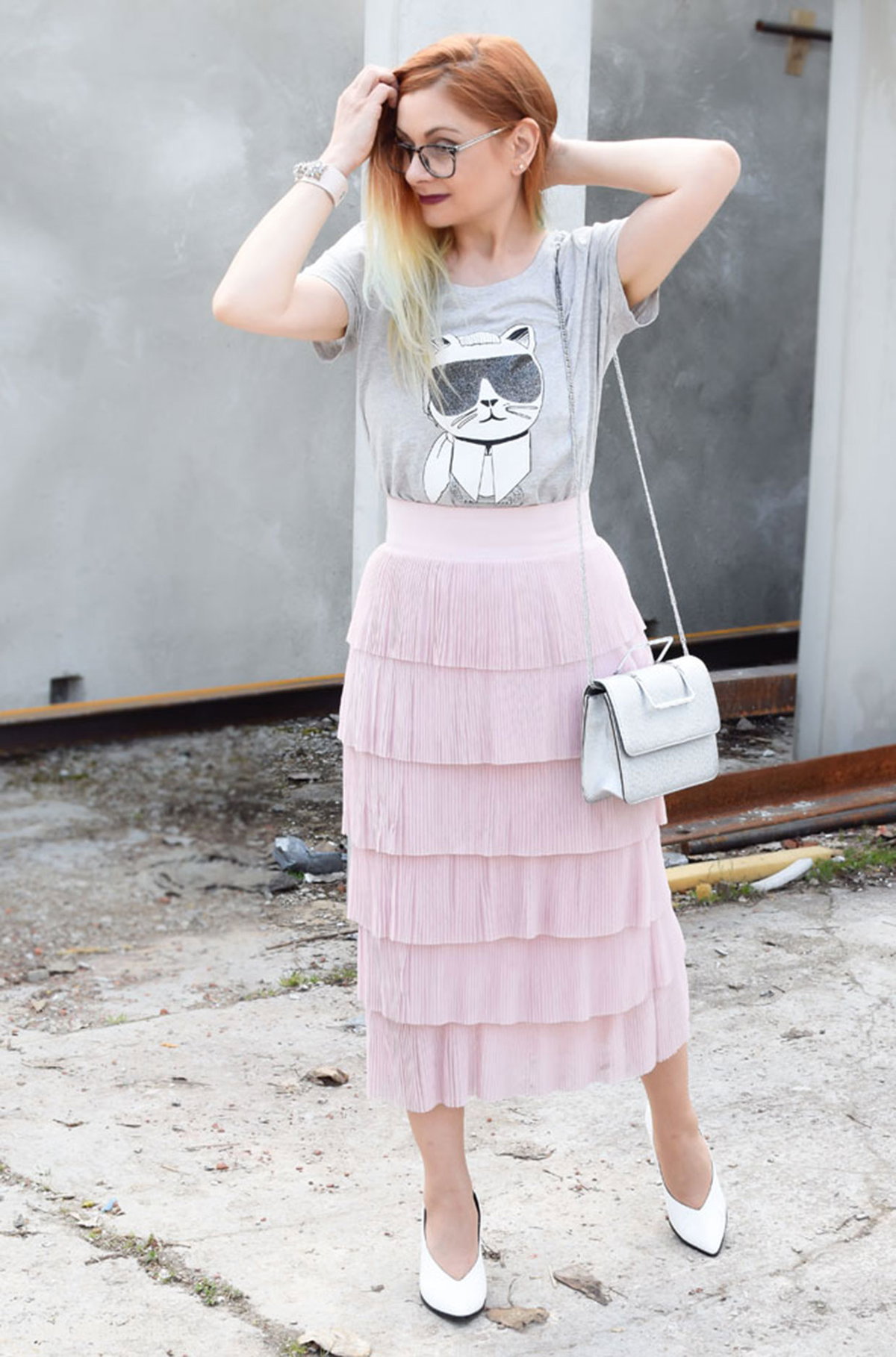 Chrissie mit grauem Karl Lagerfeld-T-Shirt zum zart rosafarbenen Rock mit Volants und weißen Pumps