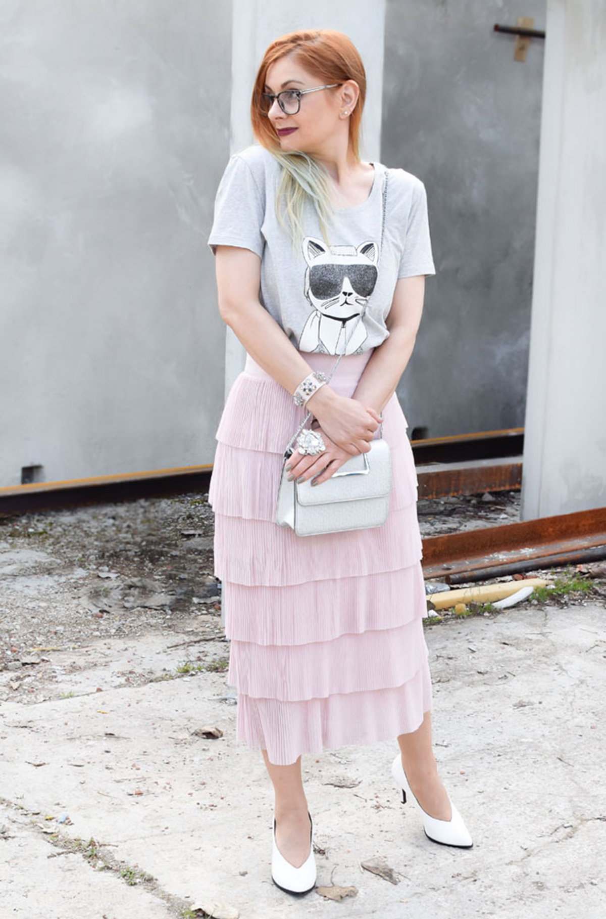Chrissie mit grauem Karl Lagerfeld-T-Shirt zum zart rosafarbenen Rock mit Volants und weißen Pumps