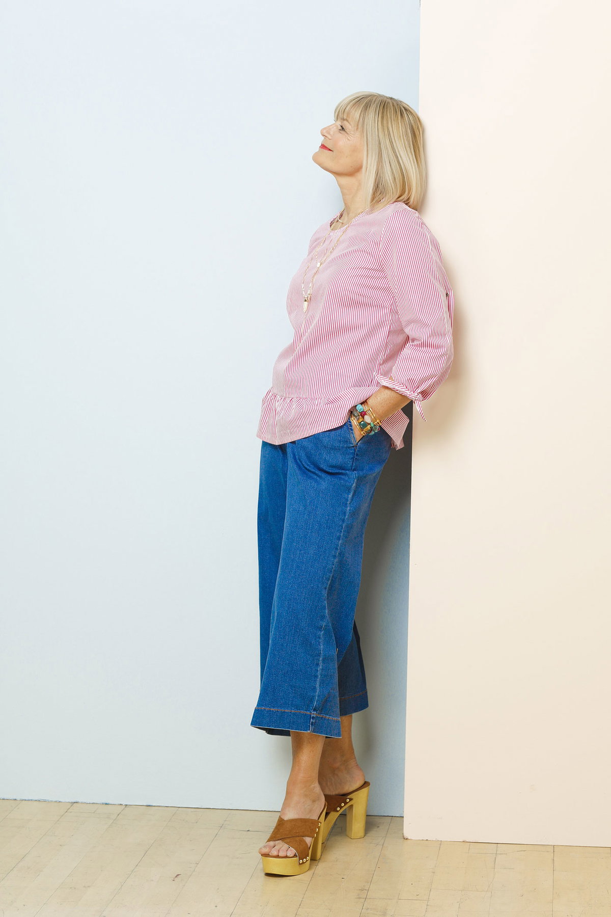Andrea trägt eine rot-weiß-gestreifte Bluse zu Denim-Culottes und Holz-Sandalen