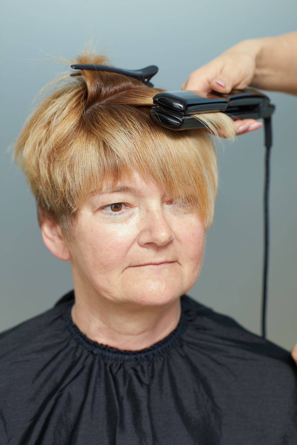 Gabys Haare werden mit einem Glätteisen geglättet