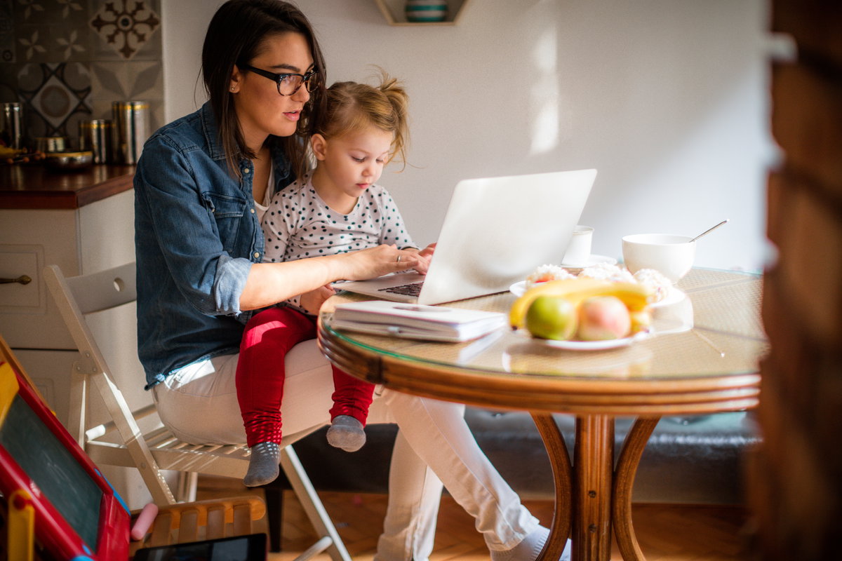 Alleinerziehende Frau mit Kind am Laptop