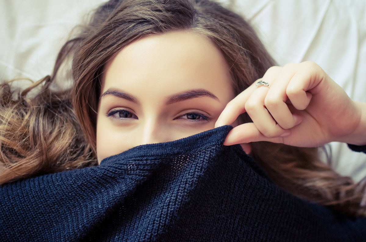 Frau versteckt sich in Pullover