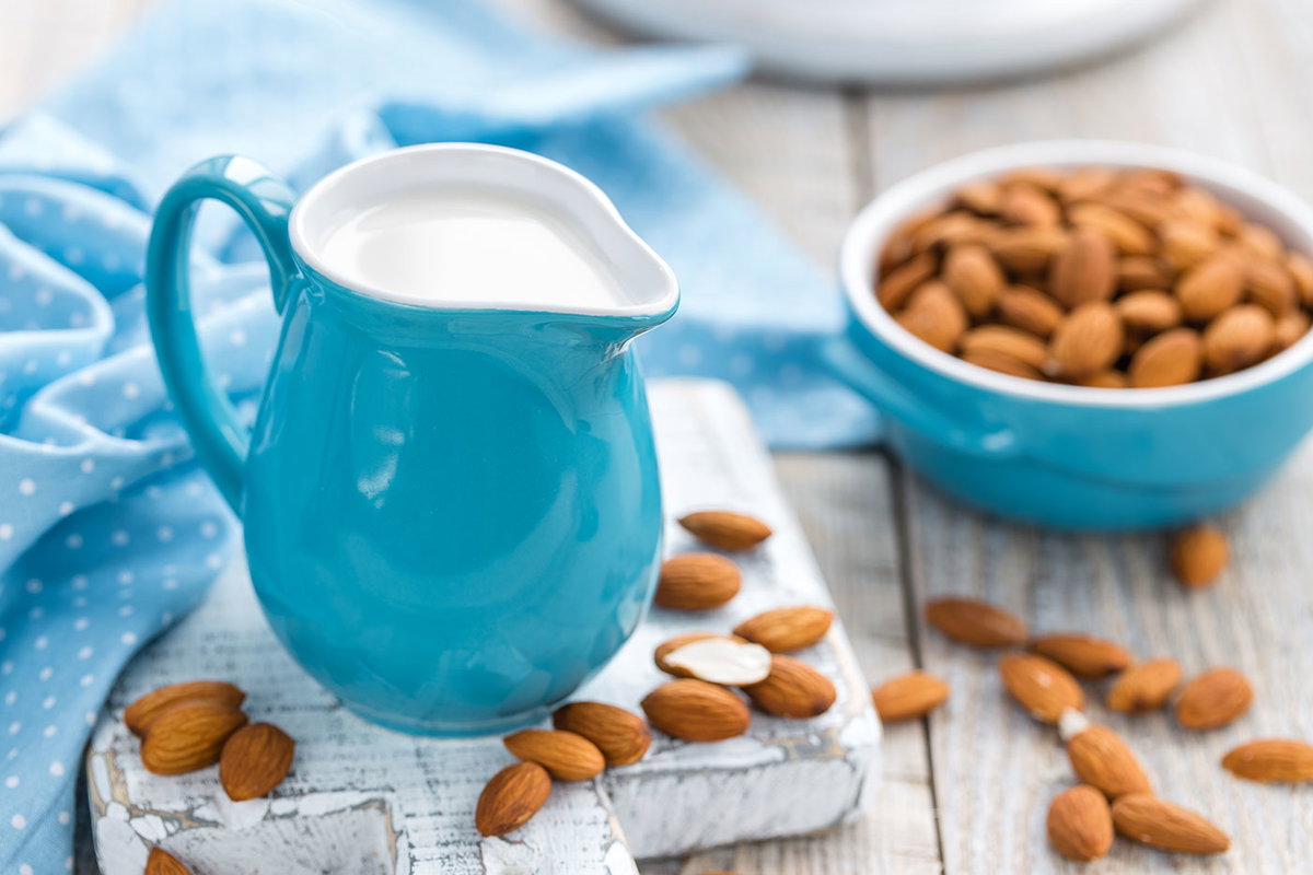 Kännchen mit Mandelmilch und Schüssel mit Mandeln