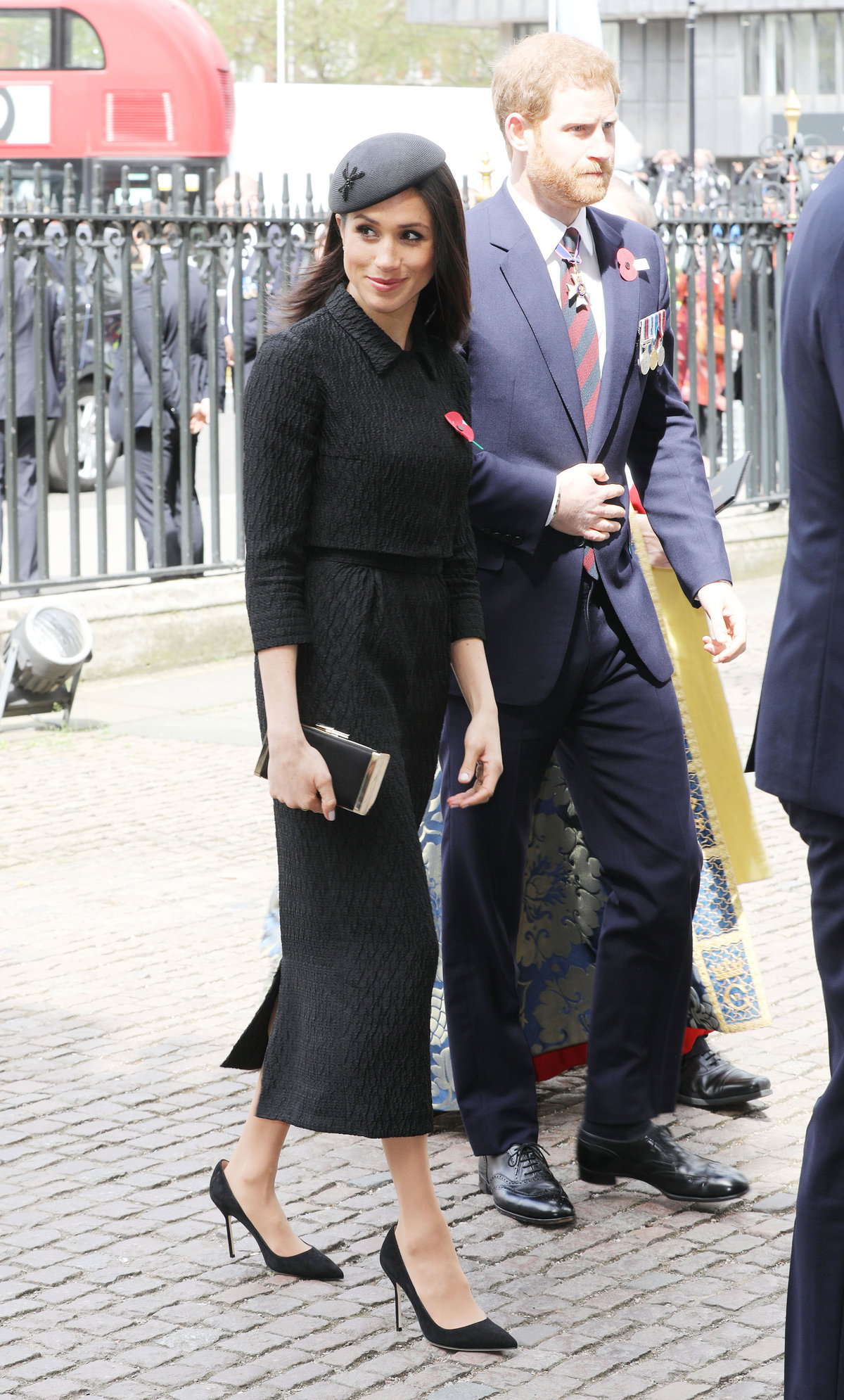 Meghan Markle im eleganten, schwarzen Kostüm mit Bleistiftrock, kurzem Jäckchen, Barett und Highheels