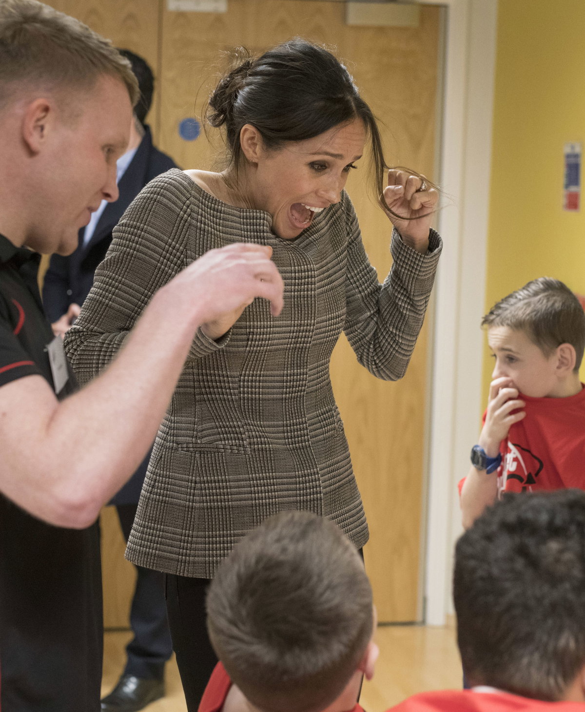 Meghan Markle in einem karierten Jäckchen mit Kindern in einem Gemeinschafts- und Freizeitzentrum in Wales