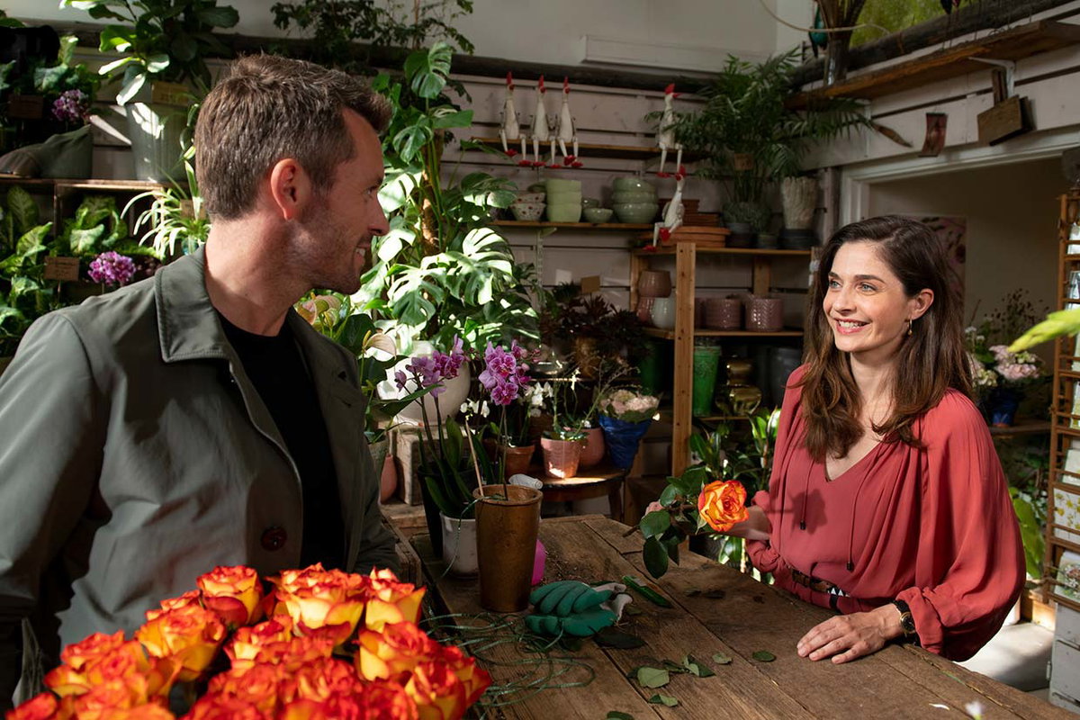 Emilia (Werner) und Alexander (Hartmann) begegnen sich im Blumenladen: Inga Lindström „Das Geheimnis der Nordquists“